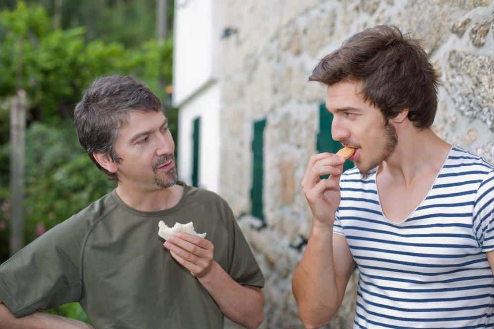 two men eating snacks