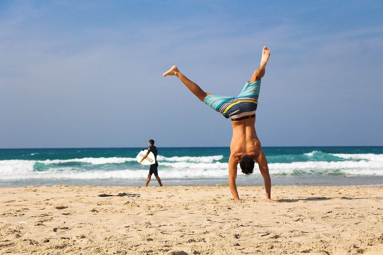 healthy happy man doing handstand